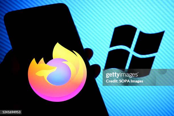 In this photo illustration, a Mozilla Firefox browser logo is displayed on a smartphone screen with a Microsoft logo in the background.