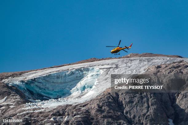 Rescue helicopter flies on July 4, 2022 over the glacier that collapsed the day before on the mountain of Marmolada, the highest in the Dolomites,...