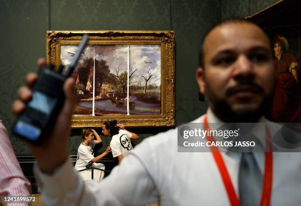 Activists from the 'Just Stop Oil' campaign group, with hands glued to the frame of the painting 'The Hay Wain' by English artist John Constable, but...