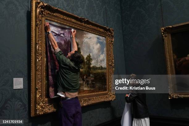 Just Stop Oil climate activists subvert The Hay Wain painting by John Constable and glue themselves to the frame at the National Gallery on the 4th...