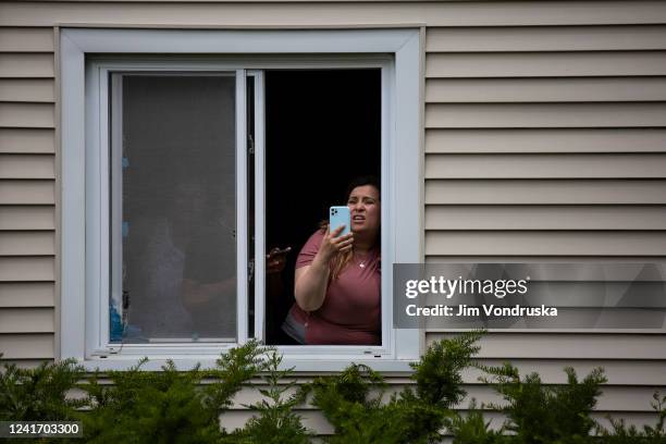 Resident uses her phone after a shooting at a Fourth of July parade on July 4, 2022 in Highland Park, Illinois. Reports indicate at least six people...