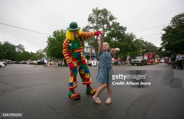 Child dances with a clown before the annual Independence Day Parade on July 4, 2022 in Southport, North Carolina. The U.S. Declaration of...