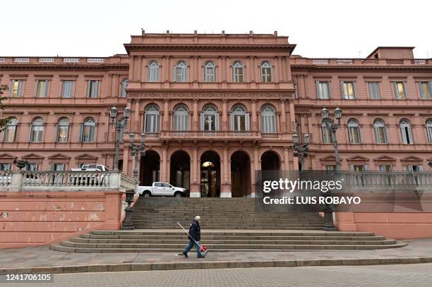 Cleaning man walks outside the Casa Rosada presidential palace, in Buenos Aires, on July 4, 2022. - Argentina appointed economist Silvina Batakis as...