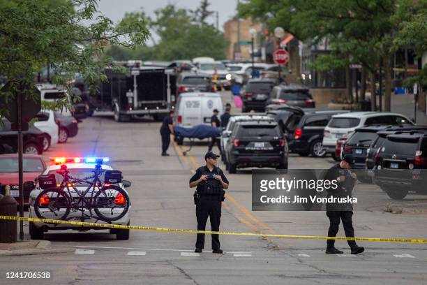 First responders take away victims from the scene of a mass shooting at a Fourth of July parade on July 4, 2022 in Highland Park, Illinois. At least...