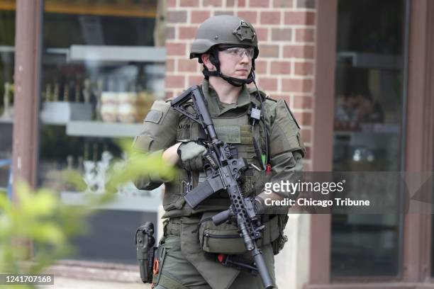 Law enforcement officer watches as people are evacuated from an Anthropologie store in Highland Park on Monday, July 4 after a shooter fired on the...