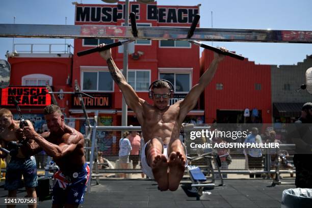 Contestants warm up ahead of the Mr. & Ms. Muscle Beach championship on Independence Day in Venice, California on July 4, 2022. - Venice is one of...