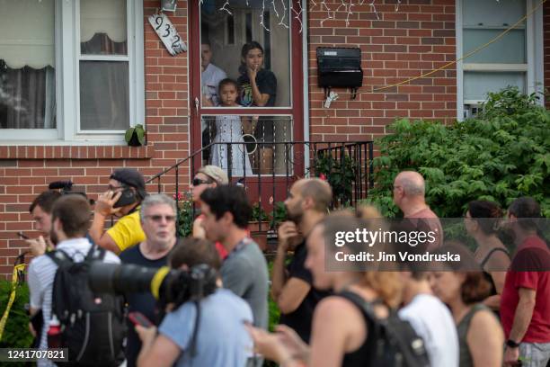 Family looks outside of their front door near the home of the mother of the man detained in the mass shooting at a Fourth of July parade on July 4,...