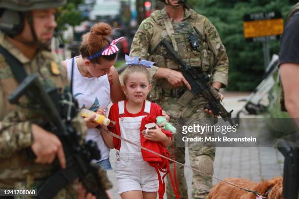 Law enforcement escorts a family away from the scene of a shooting at a Fourth of July parade on July 4, 2022 in Highland Park, Illinois. Police have...