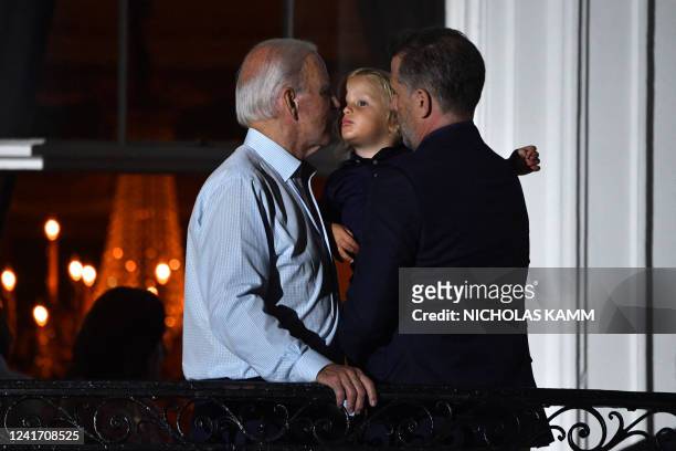 President Joe Biden holds grandson Beau Biden next to son Hunter Biden on a balcony of the White House to watch 4th of July fireworks in Washington,...