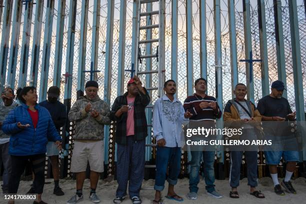 Migrants take part in a vigil for migrants who died while migrating to the United States, at the US-Mexico border in playas de Tijuana, Baja...