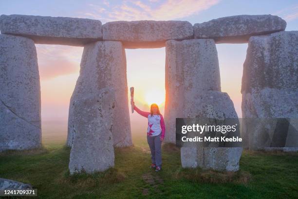 Sally Orange carries the Queen's Baton as The Queens Baton visits Stonehenge on July 5th, 2022 in England as part of the Birmingham 2022 Queens Baton...