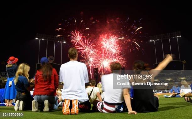 Fans and and Los Angeles Dodgers players family members watch the Independence Day fireworks at the conclusion of the game between the Colorado...