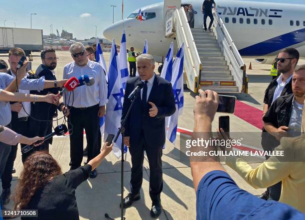 Israel's Prime Minister Yair Lapid speaks to the press ahead of boarding his flight to France, at Israel's Ben Gurion Airport in Lod on July 5, 2022....