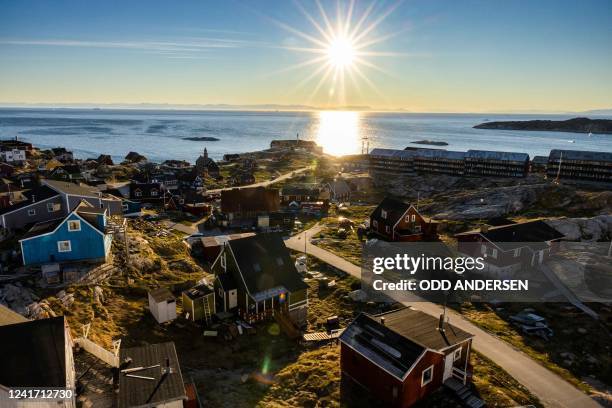 The midnight sun is seen across Disko Bay behind Ilulissat, western Greenland, on June 28, 2022.