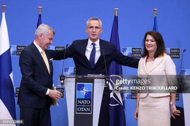 Secretary General Jens Stoltenberg embraces Finnish Foreign Minister Pekka Haavisto and Swedish Ministry for Foreign Affairs Ann Linde after the...