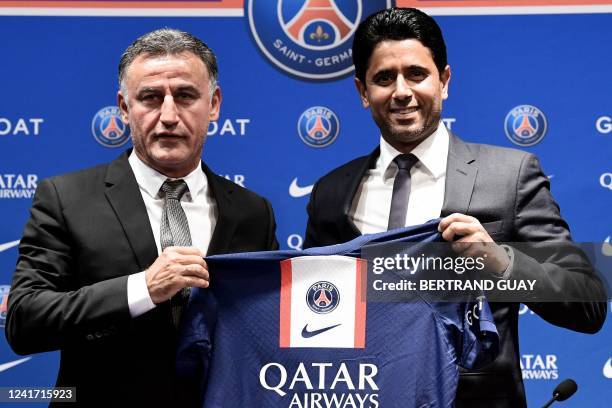 French coach Christophe Galtier and PSG's President Nasser Al-Khelaifi holds a jersey as they pose at the end of a press conference after Galtier was...