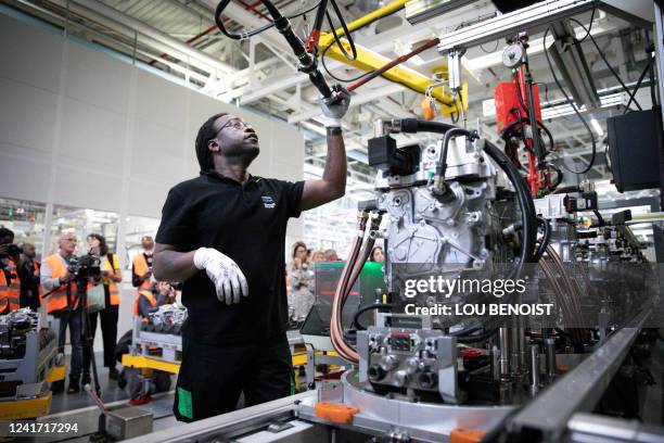 An employee works on electric car equipments, at a Renault factory, in Cleon, northwestern France, on July 5, 2022.