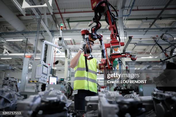 An employee works on electric car equipments, at the Renault factory, in Cleon, northwestern France, on July 5, 2022.