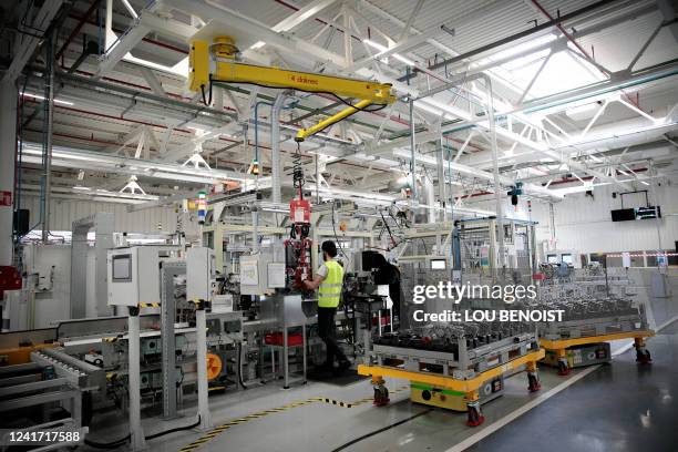 Employees work on an electric car's equipment, at the Renault factory, in Cleon, northwestern France, on July 5, 2022.