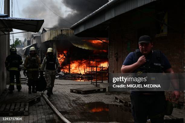 Firefighters work to control flames at the central market of Sloviansk on July 5 following a suspected missile attack amid the Russian invasion of...