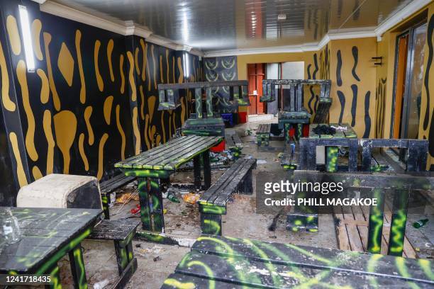 Empty alcohol bottles, wooden chairs and tables are seen inside a township pub in southern city of East London on July 5 after the death of 21...
