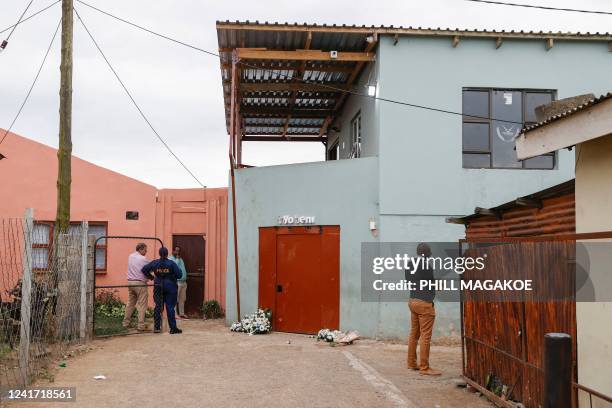 South African Police Services members stand next to the entrance of a township pub in southern city of East London on July 5 after the death of 21...