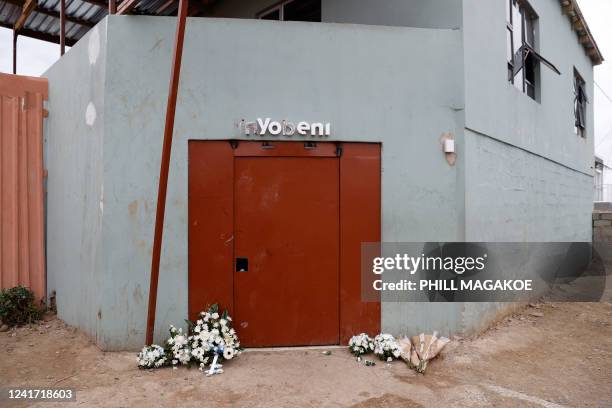 Flowers are seen at the entrance of a township pub in southern city of East London on July 5 after the death of 21 teenagers in the establishment. -...