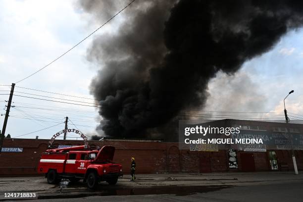 Firefighters work to control flames at the central market of Sloviansk on July 5 following a suspected missile attack amid the Russian invasion of...