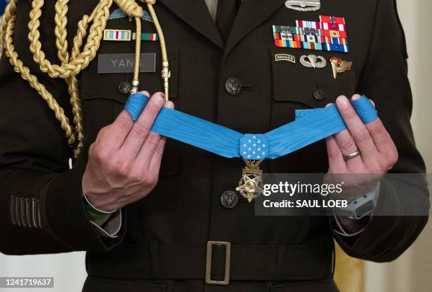 Military aide holds a Medal of Honor as US President Joe Biden awards the Medal of Honor to retired US Army Major John J. Duffy for his actions...