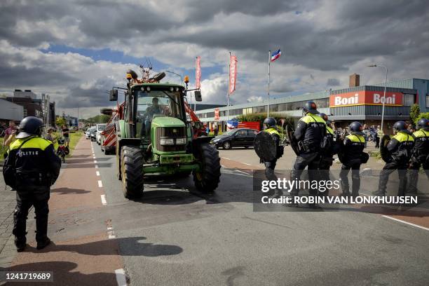 Farmers remove tractors forming a blockade at the request of the police at a distribution center of supermarket chain "Boni" during a demonstration...