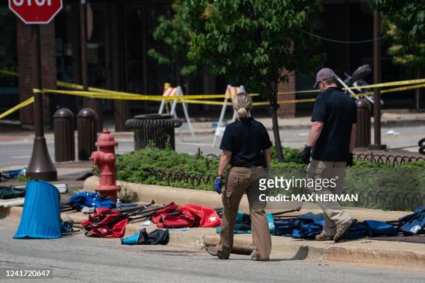 Law enforcement officers inspect chairs and belongings left behind at the scene of a mass shooting at a July 4th Parade in Highland Park, Illinois on...
