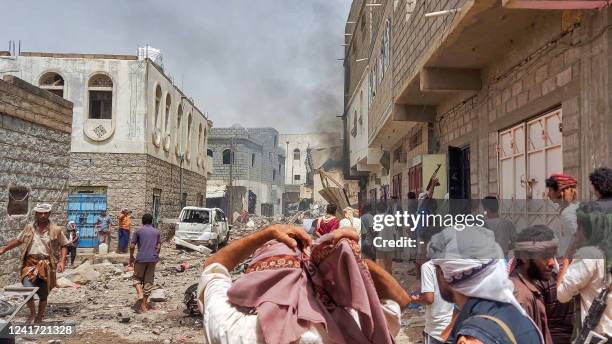 People gather at the scene near an explosion at a weapons warehouse in the city of Lawdar in Yemen's southern province of Abyan on July 5, 2022. - At...