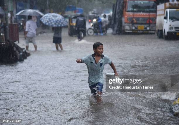 People wade through waterlogged road due to heavy rain on Nagardas Road, near Andheri Subway, at Andheri on July 5, 2022 in Mumbai, India. Mumbai has...