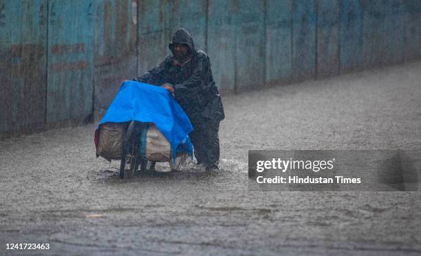 People wade through waterlogged road due to heavy rain at Kurla on July 5, 2022 in Mumbai, India. Mumbai has been witnessing heavy rain amid monsoon...