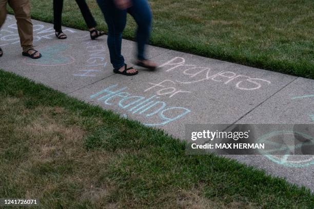 Messages of healing are written in chalk on the sidewalk in front of Highland Park Presbyterian Church, site of a prayer vigil for the victims of the...