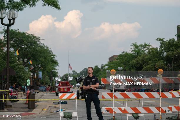 Police officer guards the area of the 4th of July mass shooting in Highland Park, Illinois on July 5, 2022. - The suspected gunman who opened fire on...