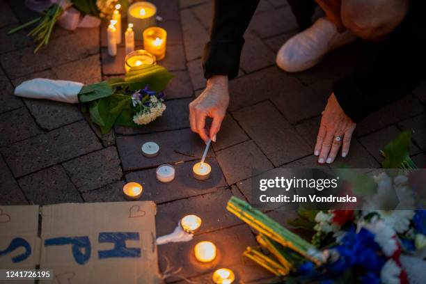 People light candles during a vigil near the scene of a mass shooting yesterday at a Fourth of July parade, on July 5, 2022 in Highland Park,...