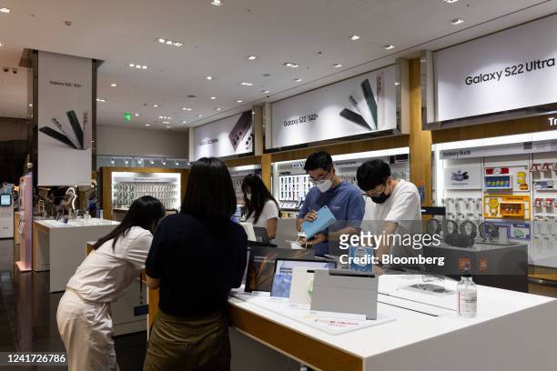 Customers try out Samsung Electronics Co. Galaxy Tab tablet devices smartphones at the company's D'light flagship store in Seoul, South Korea, on...