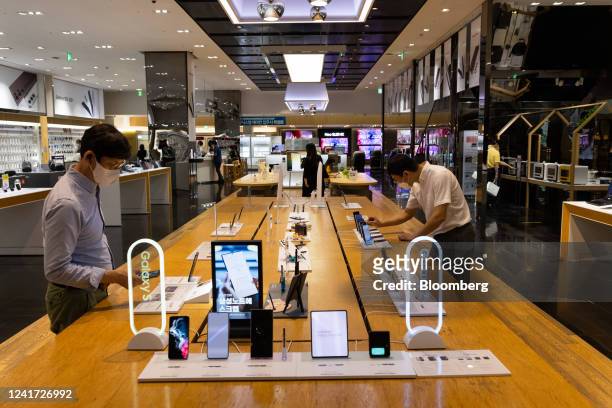 Customers try out Samsung Electronics Co. Galaxy smartphones at the company's D'light flagship store in Seoul, South Korea, on Tuesday, July 5, 2022....