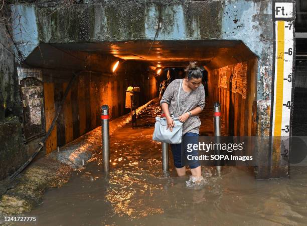 Woman walks out of a flooded subway amidst heavy rain in Mumbai. Mumbai experienced flooded streets in low-lying areas, and traffic was slow-moving...