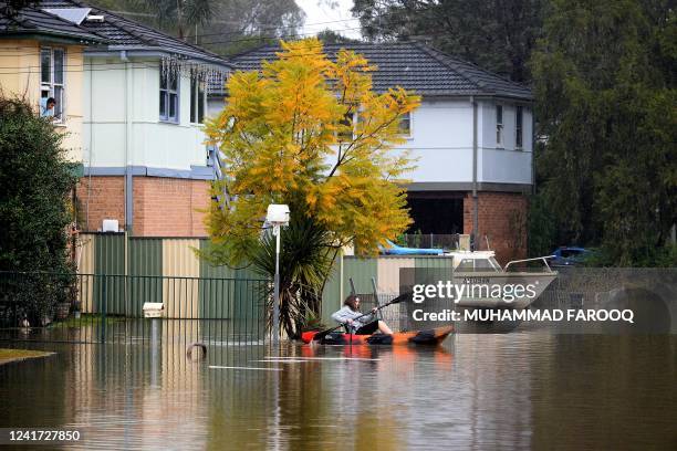 Resident paddles a kayak to commute from her flooded residential area near the overflowing Hawkesbury River in the northwestern Sydney suburb of...