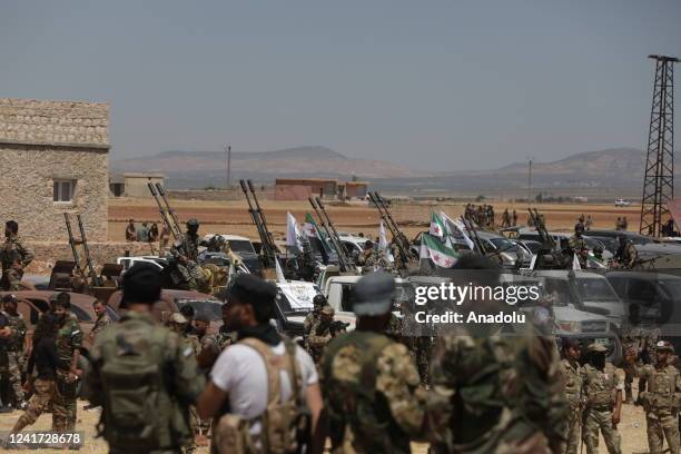 Syrian National Army members prepare the vehicles and heavy machine guns, multi-barrel rocket launchers and mortars for possible operation against...