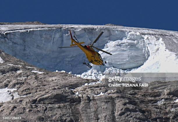 Rescue helicopter flies over the Punta Rocca glacier that collapsed near Canazei, on the mountain of Marmolada, after a record-high temperature of 10...