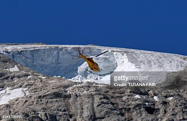 Rescue helicopter flies over the Punta Rocca glacier that collapsed near Canazei, on the mountain of Marmolada, after a record-high temperature of 10...