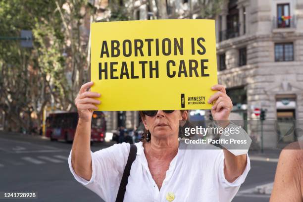 Member of Amnesty International Italia holding a placard participates in a protest against the abolition of abortion in the United States of America.