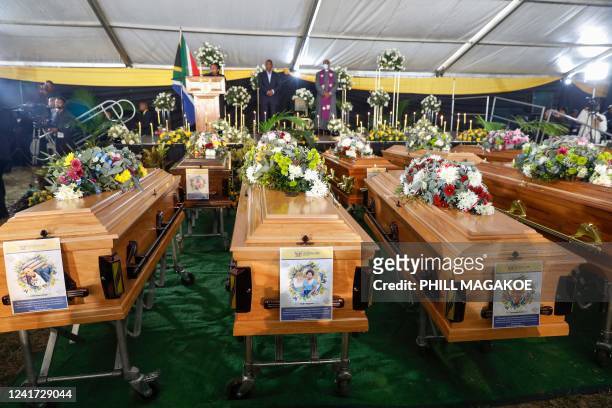 Portraits of some teenagers are seen on empty coffins during symbolic mass memorial service in East London on July 6 after 21 people, mostly teens,...