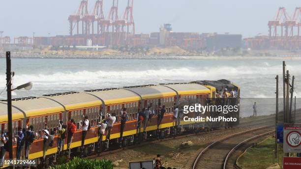Sri Lankan commuters hang on to the over-crowded train as it arrives at Colombo, Sri Lanka. 6 July 2022. Sri Lanka has less than a days worth of fuel...