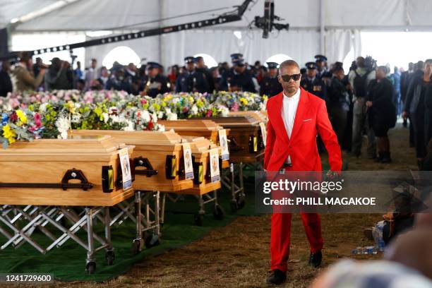 Mourner walks past empty coffins used in a symbolic mass memorial service in East London on July 6 after 21 people, mostly teens, died in unclear...