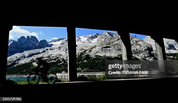 Cyclist passes through a tunnel in front of the Punta Rocca glacier that collapsed near Canazei, on the mountain of Marmolada, after a record-high...
