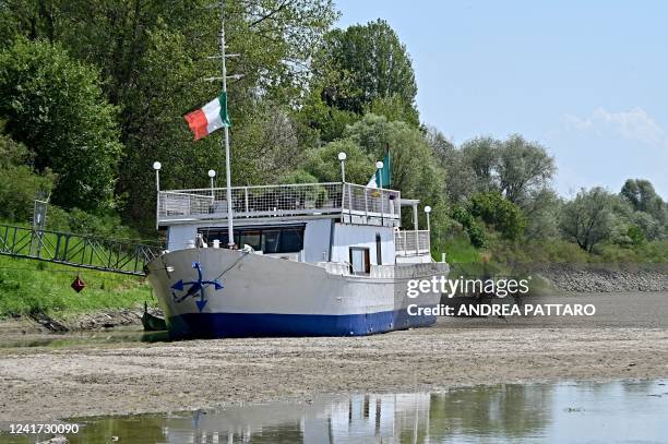 This photo taken on July 5 show a boat lying on the river bed due to low levels of the Po River in the area of the municipality of Ficarolo, in the...